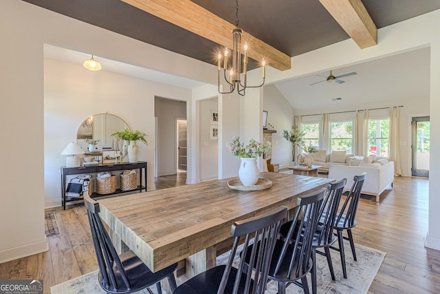 dining area with vaulted ceiling with beams, ceiling fan with notable chandelier, and light hardwood / wood-style flooring