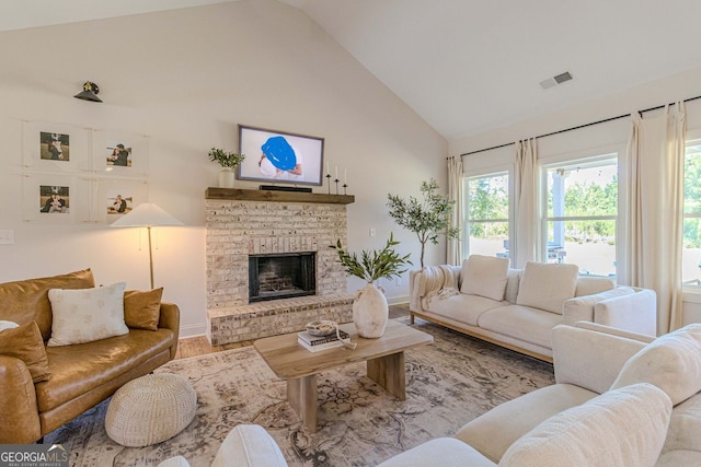 living room with wood-type flooring, a brick fireplace, and high vaulted ceiling