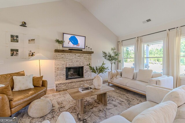 living room featuring high vaulted ceiling, a fireplace, and hardwood / wood-style flooring