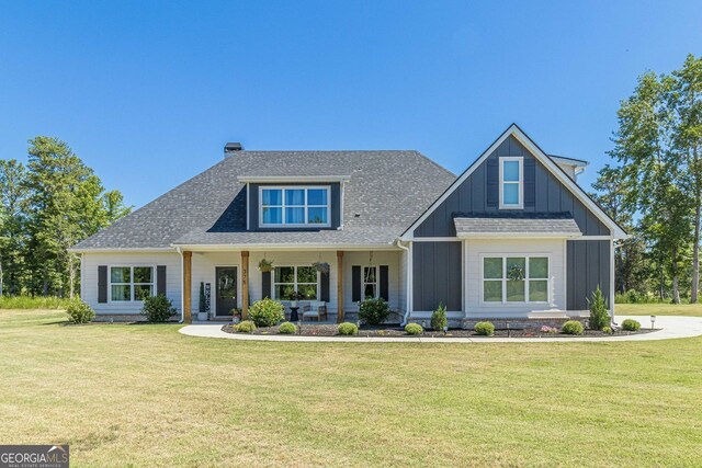 view of front of home with a porch and a front yard