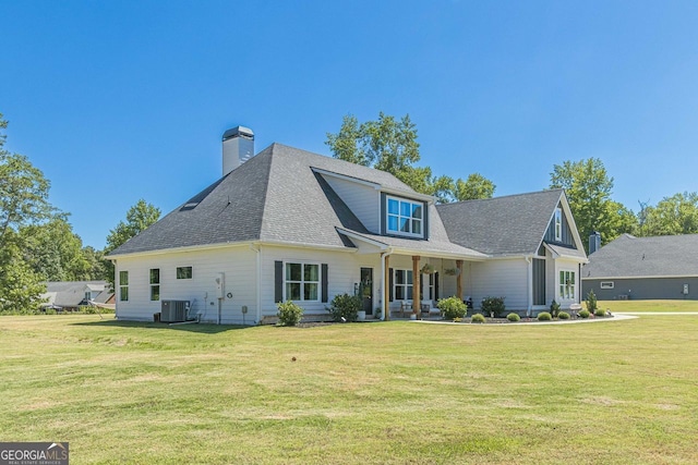 view of front of property with central air condition unit and a front lawn