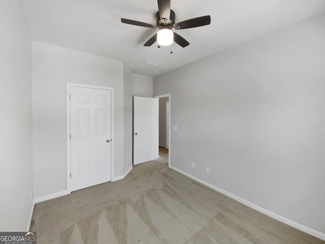 unfurnished bedroom with ceiling fan and light carpet