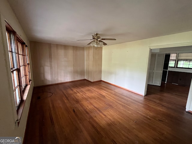 empty room featuring dark hardwood / wood-style flooring and ceiling fan