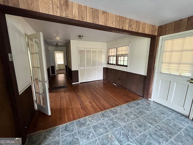 foyer entrance with wood walls and hardwood / wood-style floors