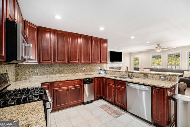 kitchen with backsplash, sink, light stone countertops, kitchen peninsula, and stainless steel appliances