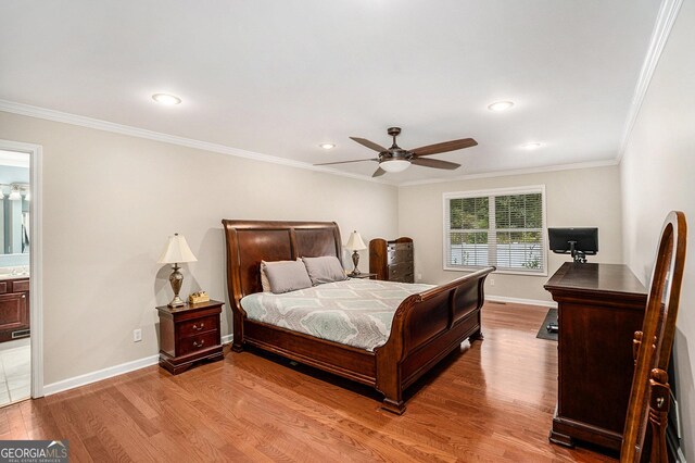 bedroom featuring ceiling fan, light wood-type flooring, crown molding, and ensuite bath