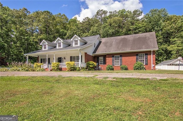 new england style home with covered porch and a front yard