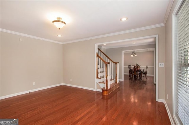 empty room with crown molding, dark hardwood / wood-style flooring, and an inviting chandelier