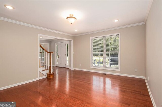 spare room with dark hardwood / wood-style flooring and ornamental molding