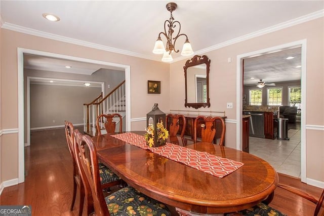 tiled dining room featuring crown molding and ceiling fan with notable chandelier