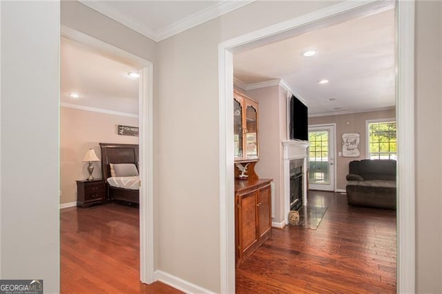 corridor with dark hardwood / wood-style flooring and ornamental molding