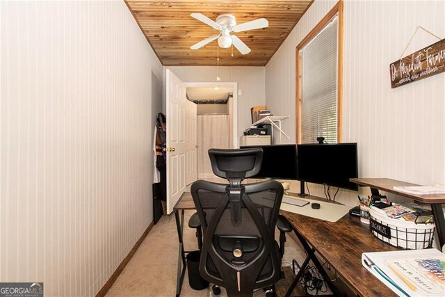 carpeted home office featuring ceiling fan, wooden walls, and wooden ceiling