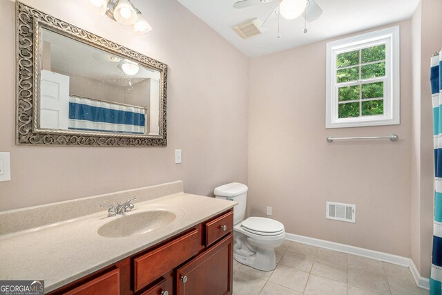 bathroom featuring tile patterned floors, walk in shower, vanity, ceiling fan, and toilet