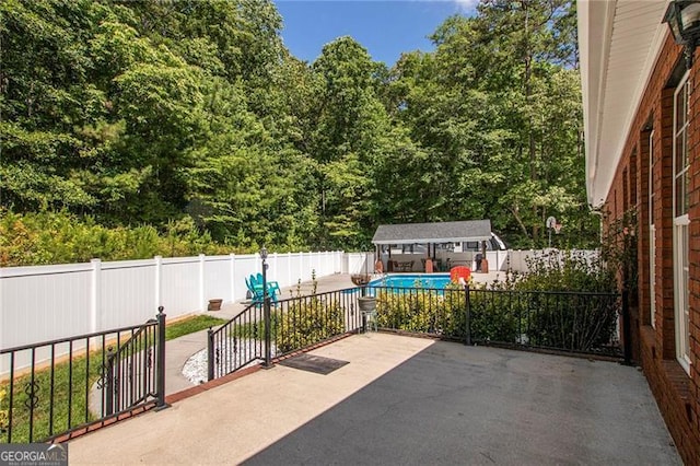 view of patio / terrace with a fenced in pool and an outbuilding