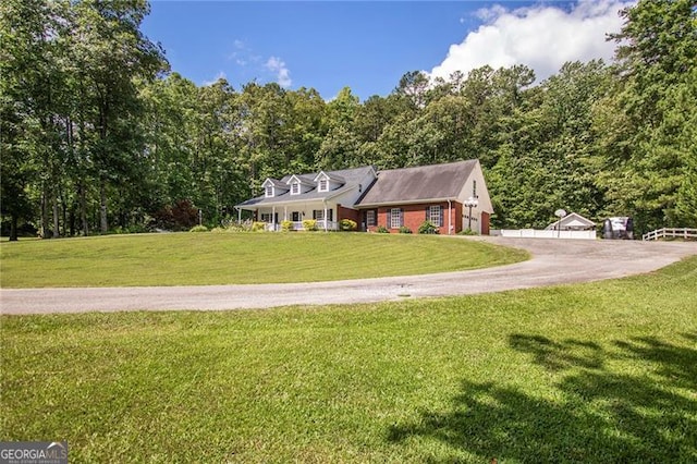 cape cod home featuring a front yard