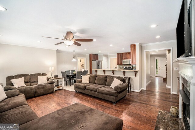 living room featuring crown molding, dark hardwood / wood-style flooring, and ceiling fan