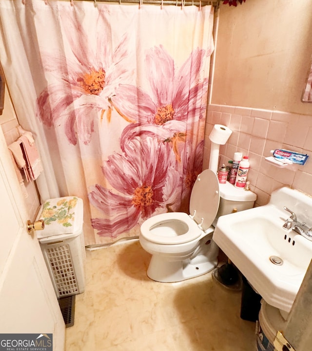 bathroom featuring toilet and tile walls