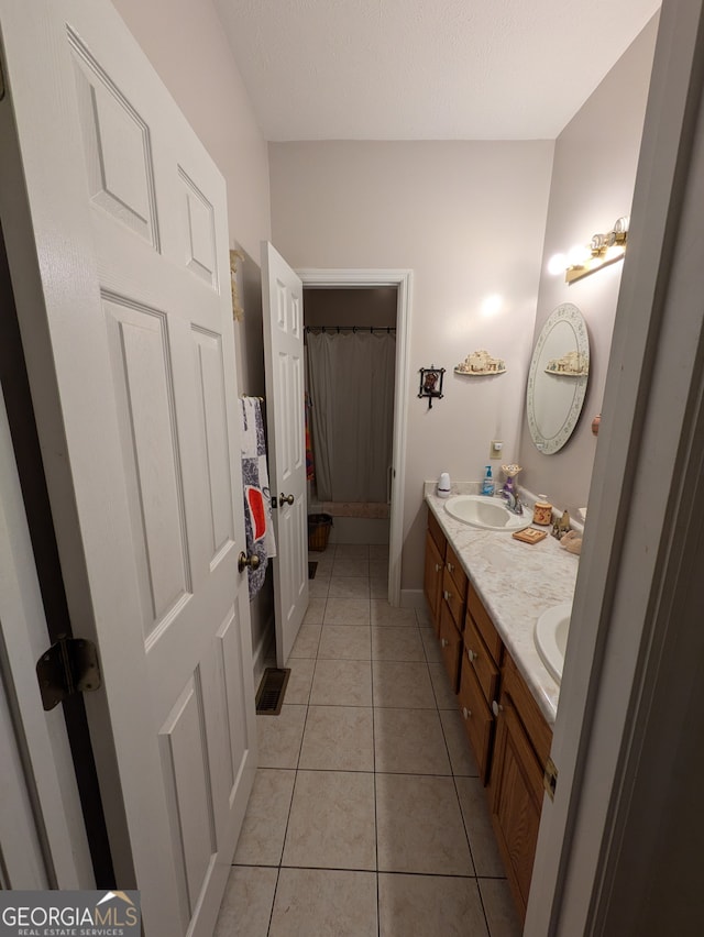 bathroom featuring tile patterned floors and dual bowl vanity