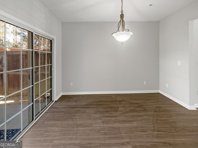 unfurnished room featuring baseboards and wood finished floors