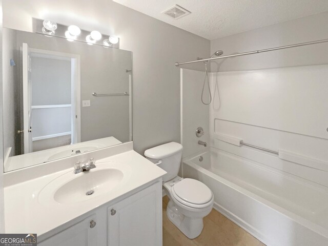 full bathroom featuring ceiling fan, vanity, a textured ceiling, shower / washtub combination, and toilet