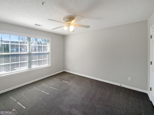 unfurnished room with a ceiling fan, visible vents, carpet floors, baseboards, and a textured ceiling