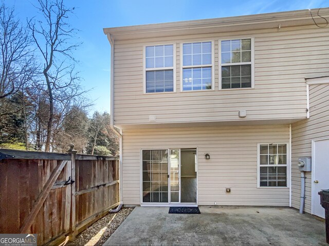 rear view of property with a gate, a patio, and fence