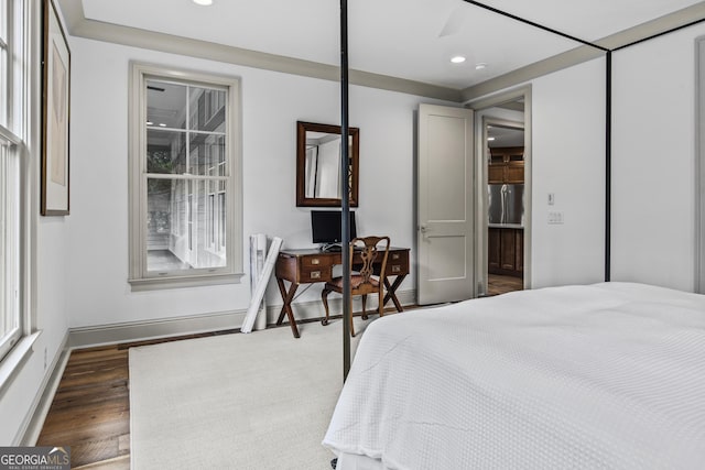 bedroom featuring stainless steel refrigerator, ceiling fan, and dark wood-type flooring