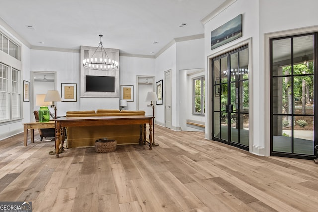 interior space featuring a chandelier, hanging light fixtures, a wealth of natural light, and light hardwood / wood-style flooring