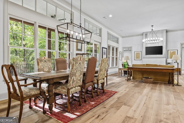 dining room with light hardwood / wood-style flooring and an inviting chandelier