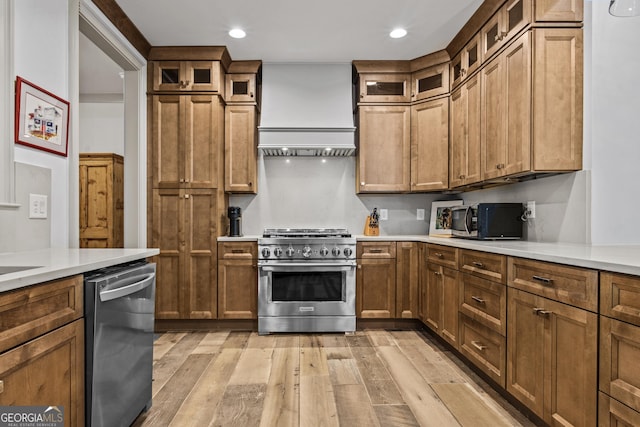 kitchen featuring custom exhaust hood, stainless steel appliances, and light hardwood / wood-style flooring