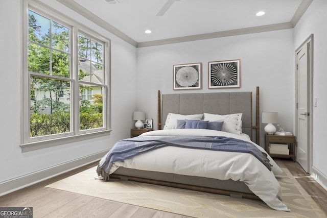 bedroom featuring ceiling fan, crown molding, and wood-type flooring