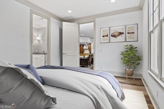 bedroom featuring hardwood / wood-style floors and connected bathroom