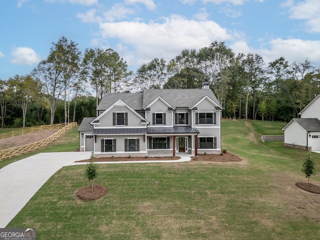 view of front of home featuring a garage, a front lawn, and covered porch