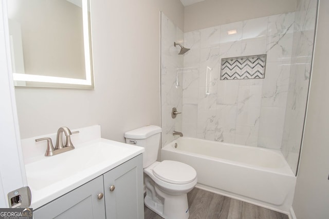 full bathroom featuring vanity, tiled shower / bath, toilet, and wood-type flooring