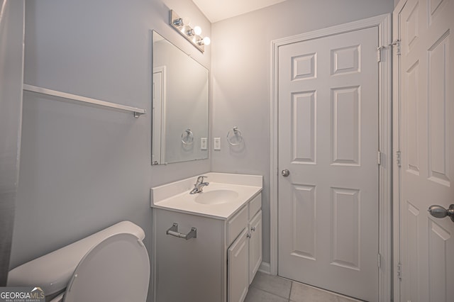 bathroom featuring tile patterned flooring, vanity, and toilet