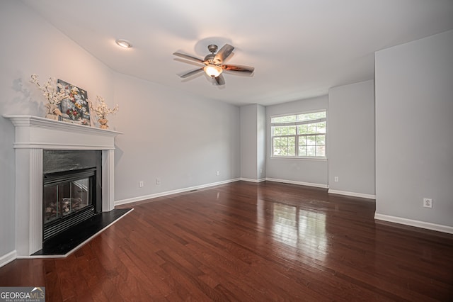 unfurnished living room with ceiling fan and dark wood-type flooring