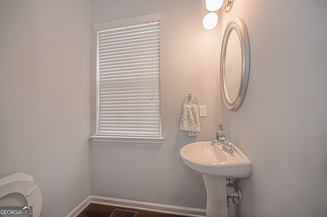 bathroom featuring wood-type flooring and toilet