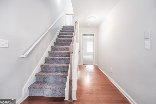 stairs featuring hardwood / wood-style floors