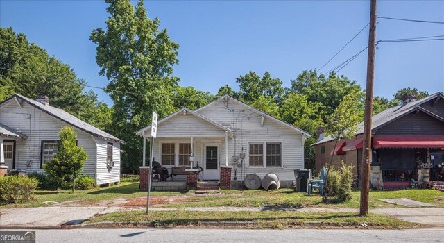 bungalow-style home with a front lawn and a porch