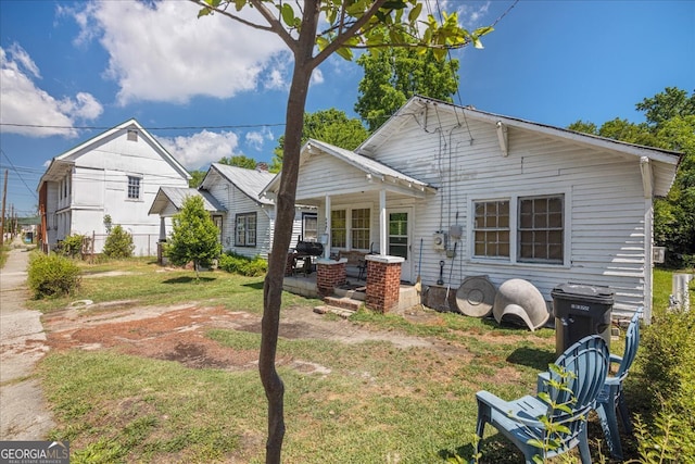 rear view of property with a lawn