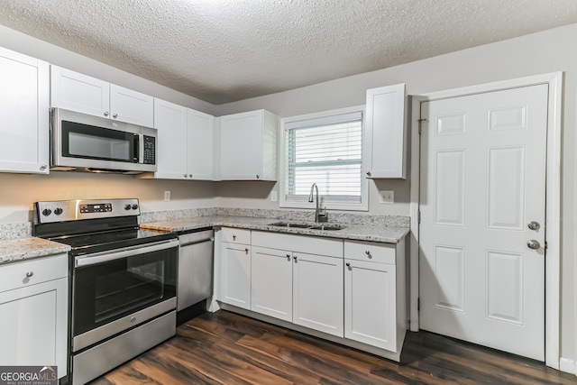 kitchen featuring dark wood-type flooring, sink, white cabinetry, and stainless steel appliances