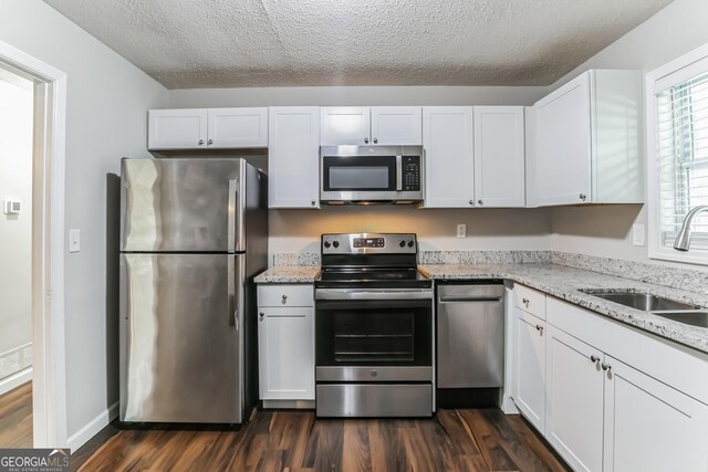 kitchen with sink, dark wood-type flooring, stainless steel appliances, and white cabinetry