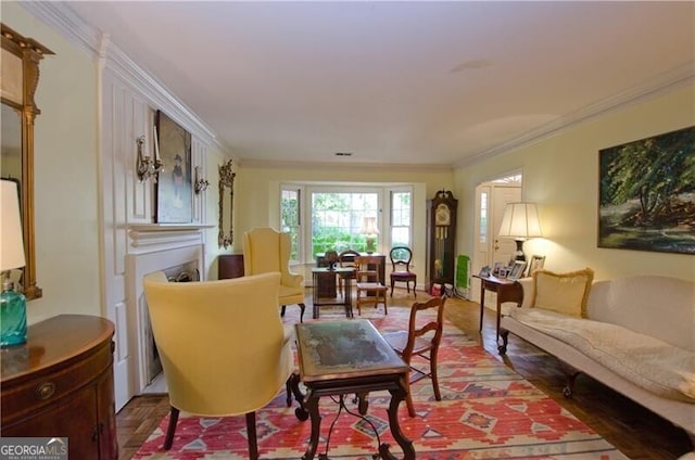 living area with hardwood / wood-style floors and ornamental molding