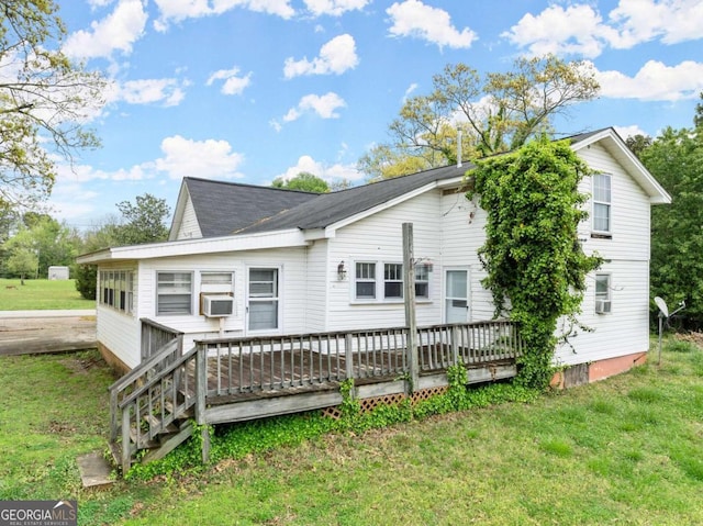 rear view of house with a lawn and a wooden deck