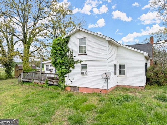 back of house featuring a lawn and a deck