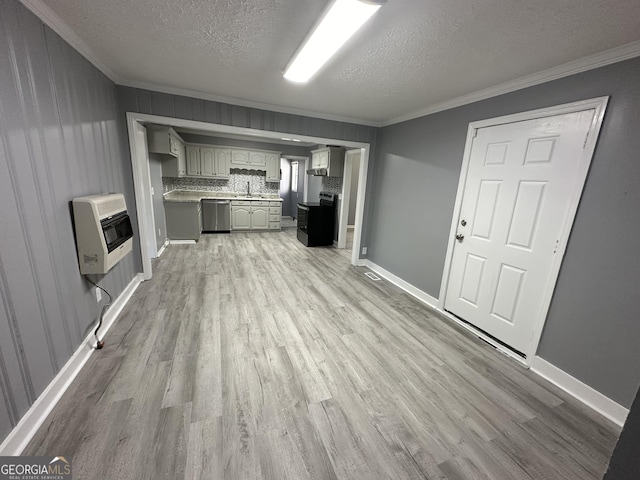 unfurnished living room featuring light wood-type flooring, a textured ceiling, heating unit, and crown molding