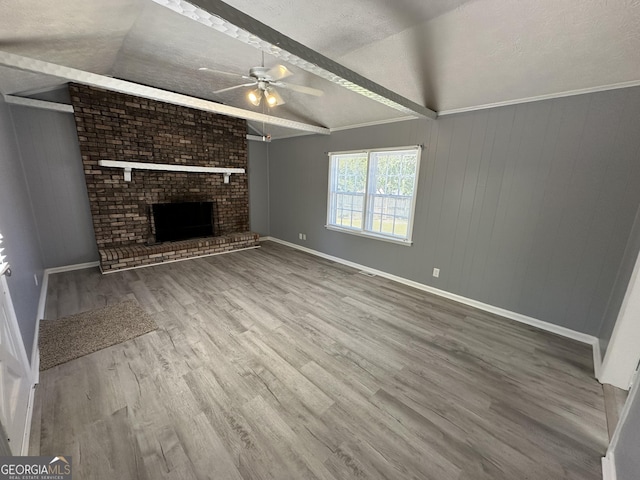 unfurnished living room featuring vaulted ceiling with beams, ceiling fan, a fireplace, and a textured ceiling