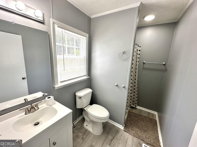 bathroom with crown molding, wood-type flooring, a textured ceiling, toilet, and vanity