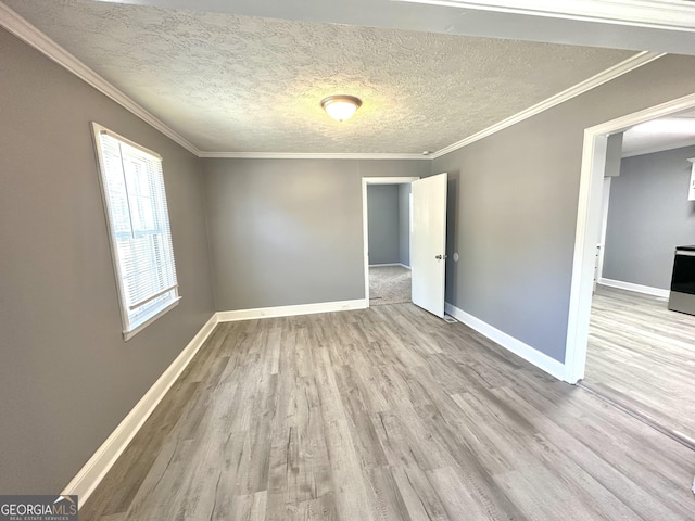 unfurnished room with a textured ceiling, light hardwood / wood-style flooring, and ornamental molding