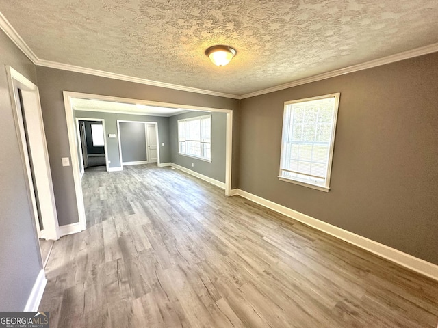 unfurnished room with crown molding, light hardwood / wood-style floors, and a textured ceiling